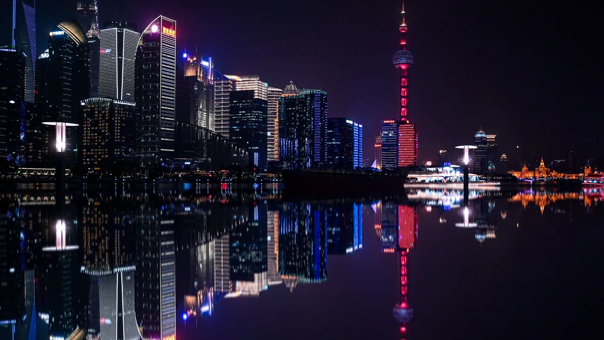 Pemandangan kota Shanghai pada malam hari dengan pantulan gedung di air