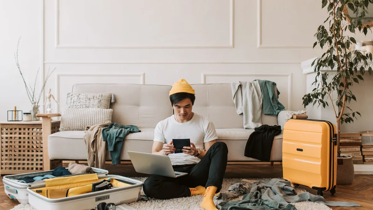 Orang menyiapkan koper dan laptop sebelum bepergian