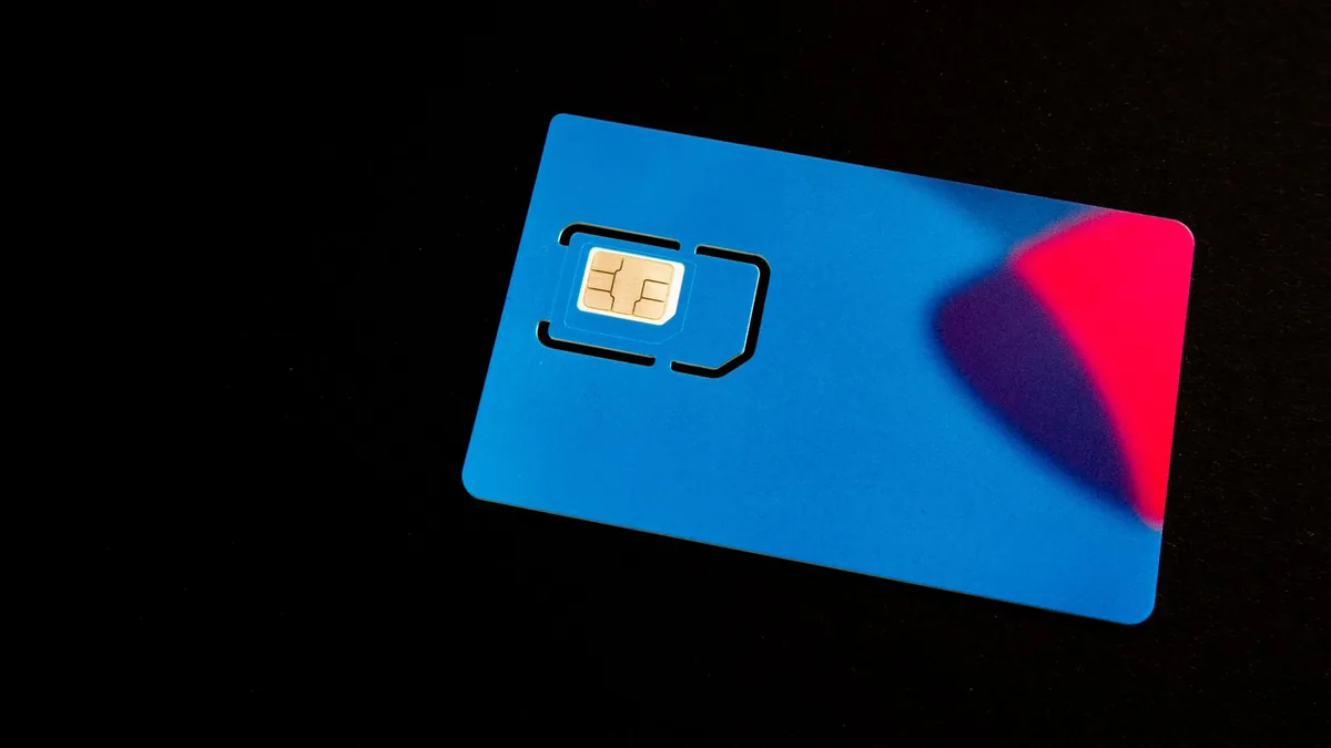 Ponsel dengan slot kartu SIM dan kartu SIM di atas meja