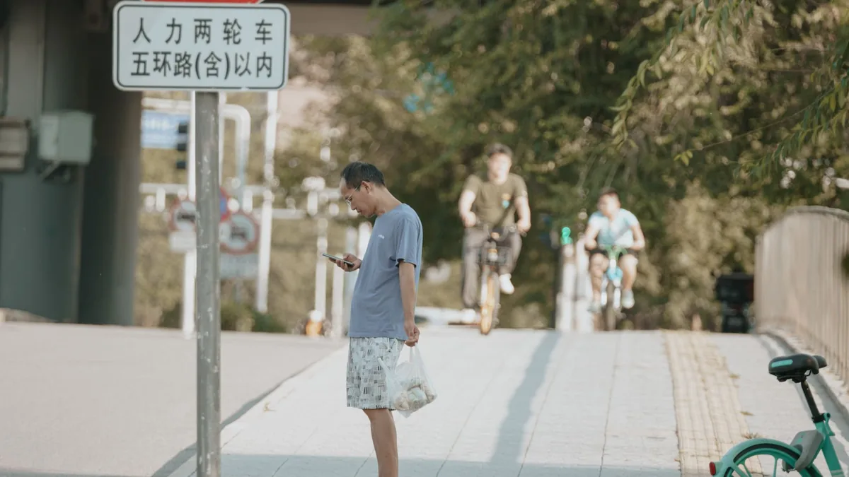 Seseorang membuka ponsel di jalan kota di China